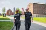 eine Justizvollzugsbeamtin und ein Justizvollzugsbeamter auf dem Außengelände der JVA