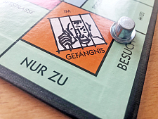 Bild eines Monopoly-Spiel-Ausschnittes mit dem Feld Im Gefängnis nur zu Besuch 