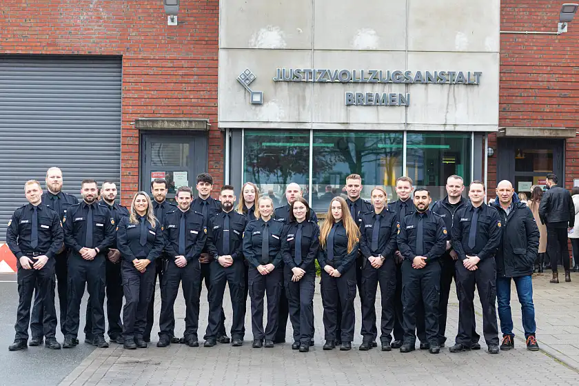 Gruppenfoto Justizvollzugsbeamtinnen und Justizvollzugsbeamte vor der JVA Bremen