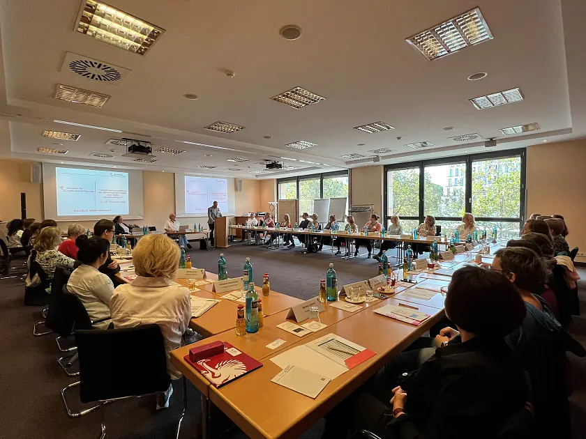 Veranstaltungsraum mit Redner und Zuhörer:innen