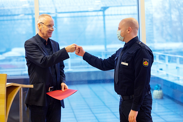 Mit einer Faus-gegen-Faust-Geste gratuliert JVA-Leiter Hans-Jürgen Erdtmann einem Absolventen zur Ernennung zum Justizvollzugsbeamten. 