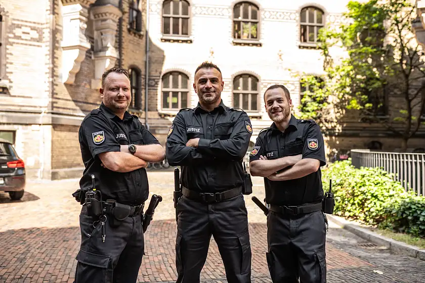 drei Justizwachtmeister im Innenhof des Landgerichts Bremen